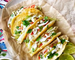Crispy potato tacos with tomatoes, onions, queso fresco, sour cream, and salsa
