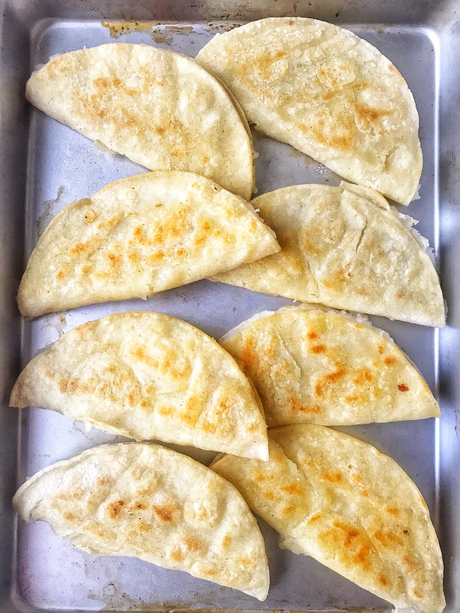 Crispy potato tacos on baking sheet pan.