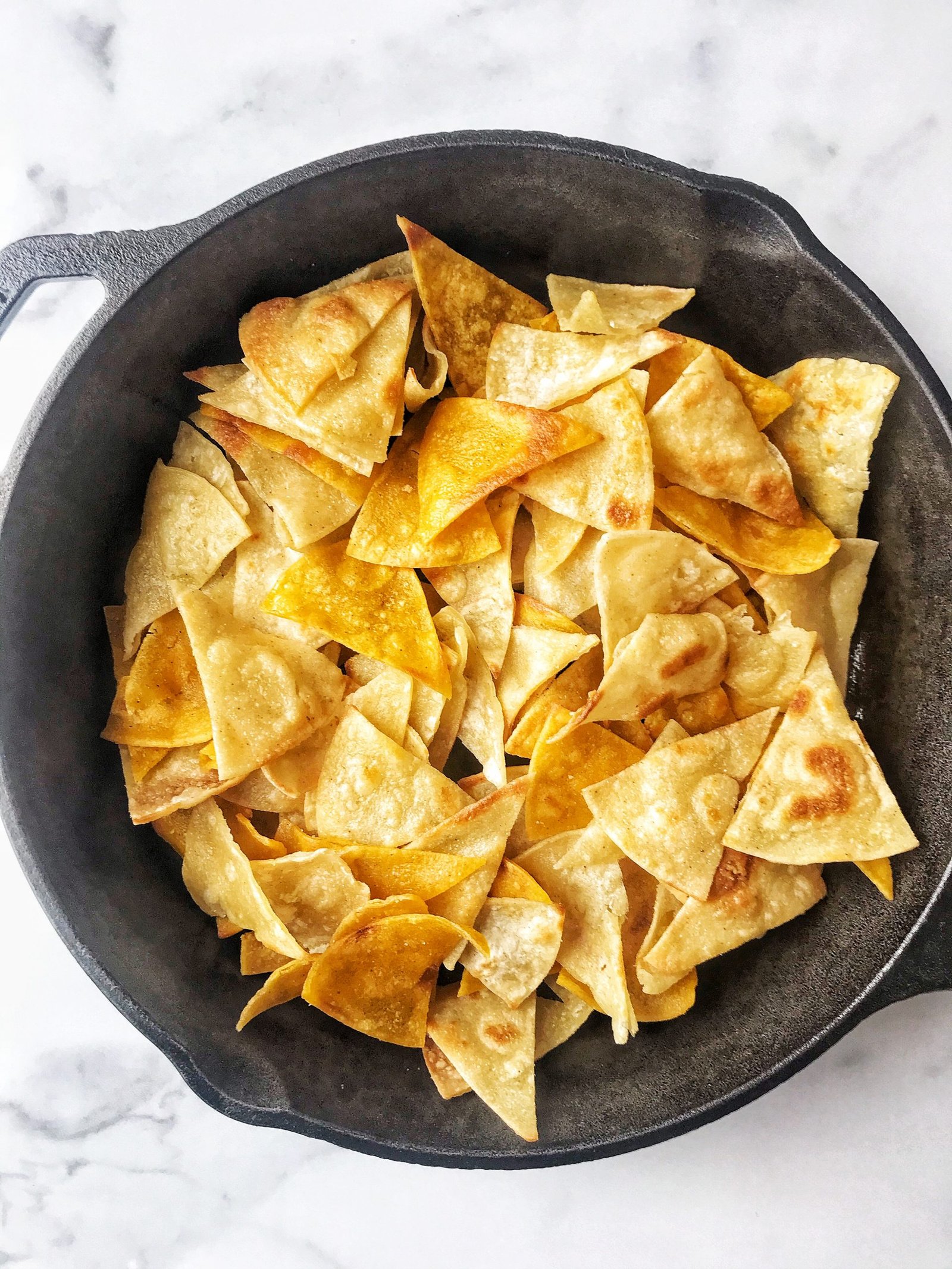 Fried tortillas; tortilla chips in cast iron skillet