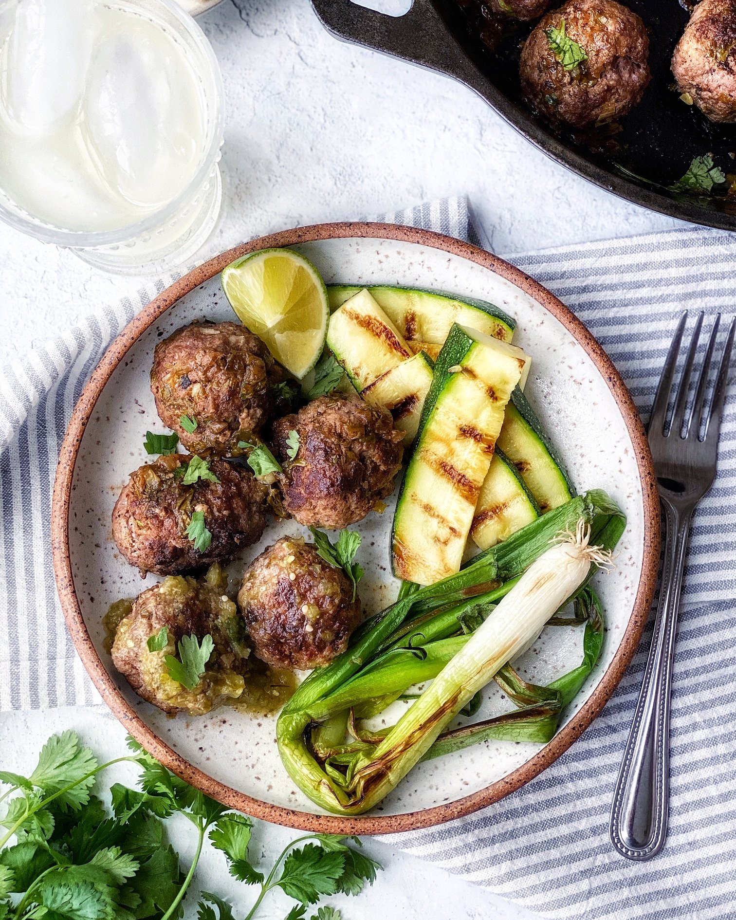 Carne asada meatballs, grilled zucchini, grilled green onions on a plate