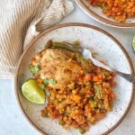 Cauliflower arroz con pollo on white plate. Chicken and cauliflower rice with vegetables.