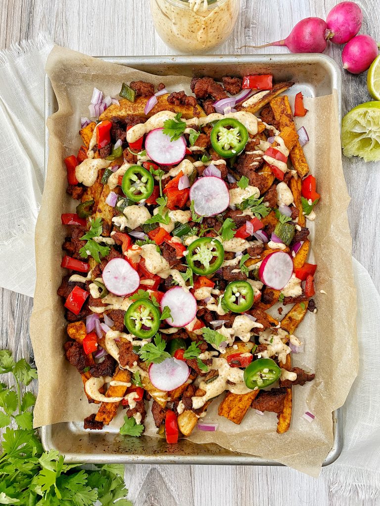 Tray of loaded chorizo fried with jalapenos, red peppers, radishes, and onion. Radishes and limes as garnish