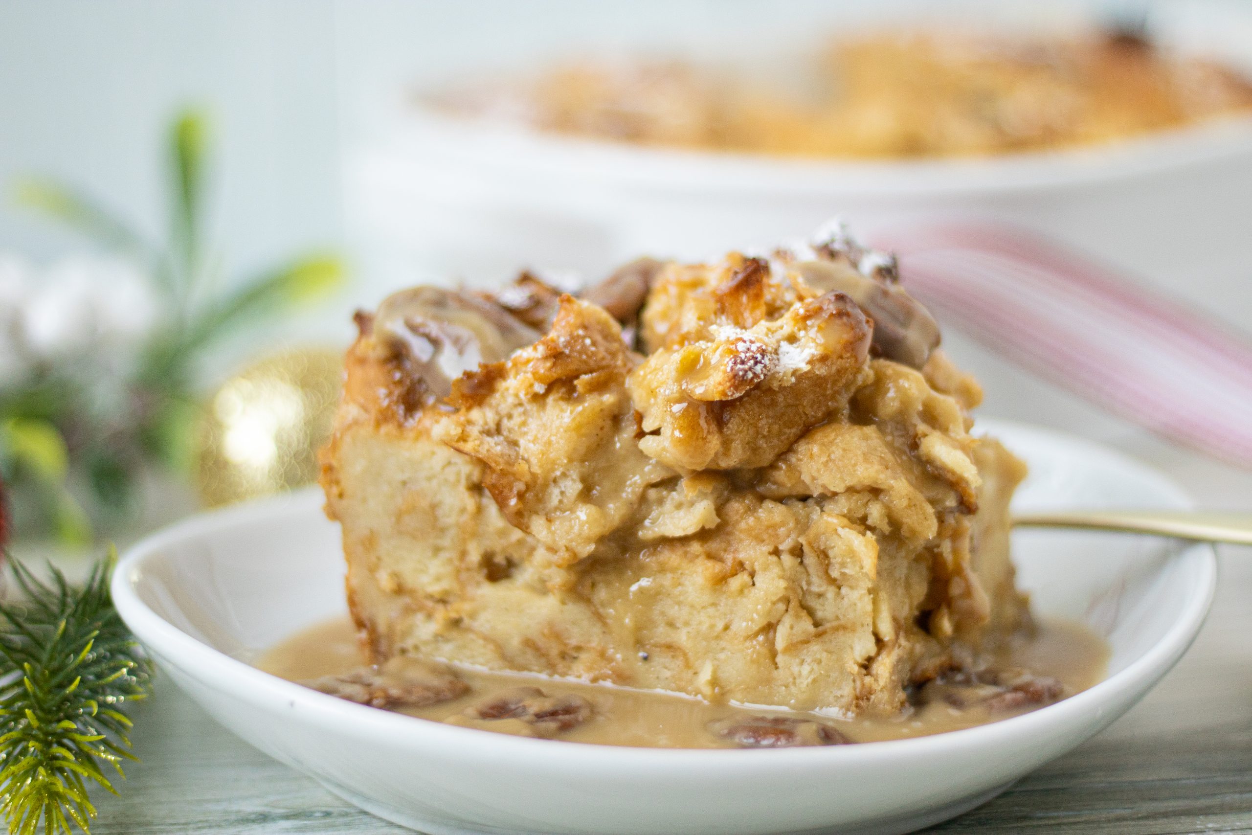 Bowl with slice of bread pudding with brown pecan sauce