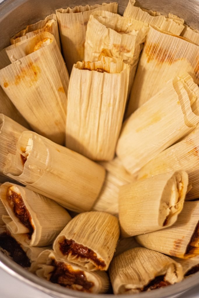 Pot full of tamales wrapped in corn husks