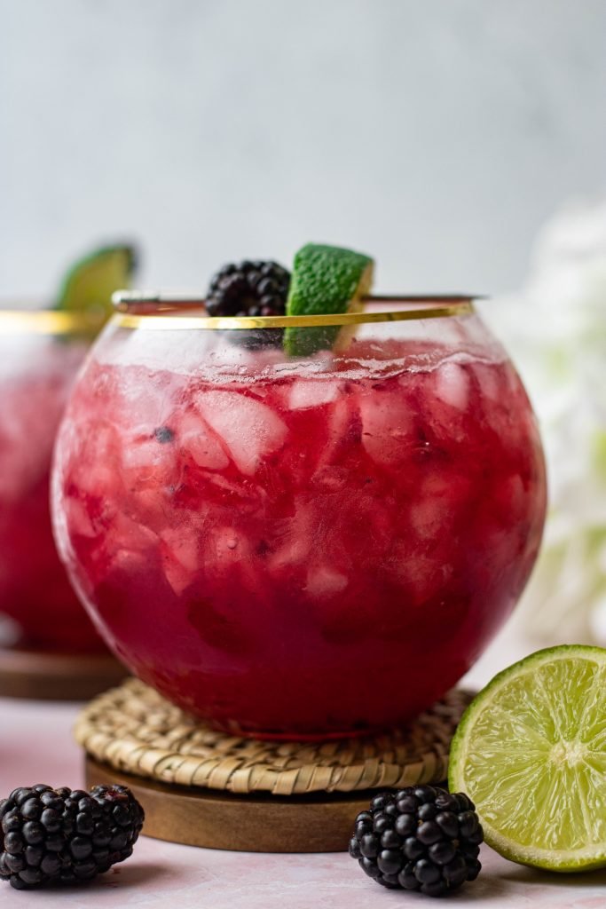 Close up of Blackberry Bourbon Smash. Blackberries and lime garnish
