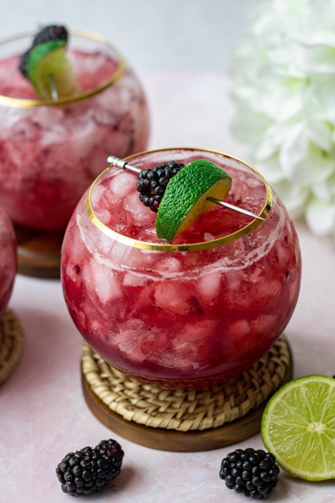 Three Blackberry Bourbon Smash cocktails with lime and blackberry garnish
